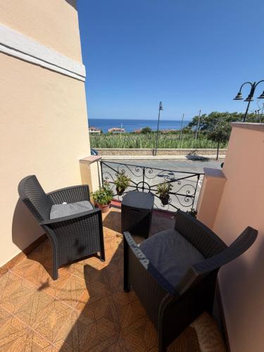 a balcony with two chairs and a table at A Due Passi da MicheIino in Parghelia