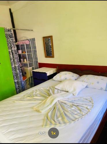 a large bed with white sheets and pillows on it at Beach cabin ometepe in Altagracia
