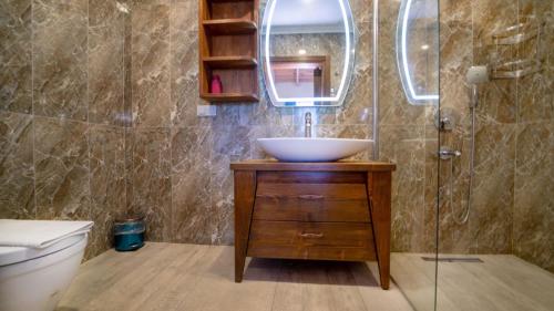 a bathroom with a sink and a toilet and a mirror at Villa Lagerta in Kayakoy
