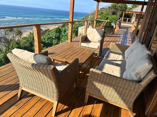a deck with two chairs and a table and chairs at Makana 7 in Ponta Mamoli