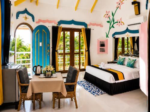 a bedroom with a bed and a table and chairs at MG Chateau Resort in El Nido