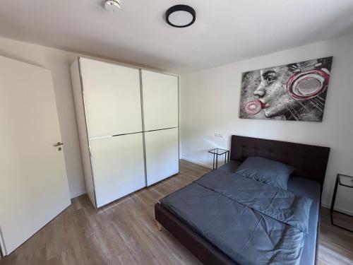 a bedroom with a bed and a white cabinet at FeWo Alissa in Nordrach