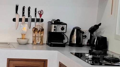 a kitchen counter with utensils on a counter top at Duplex villa in Khlaung Phai Bae