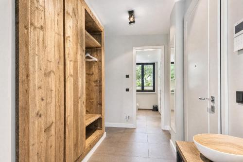 a bathroom with a wooden door and a sink at Ferienwohnung Heimathafen Villa Martha Binz in Binz
