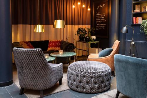 a living room with chairs and a couch and a table at Home Hotel Temperance in Malmö