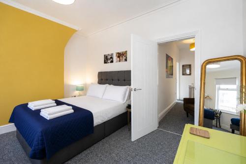 a bedroom with a large bed and a mirror at Earp House - Allerton Liverpool Stay - Sleeps 7 in Liverpool