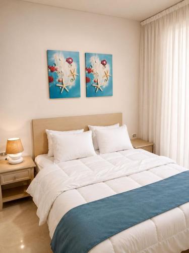 a bed in a bedroom with three paintings on the wall at Porto Sharm Elshiekh Vacation Hotel in Sharm El Sheikh