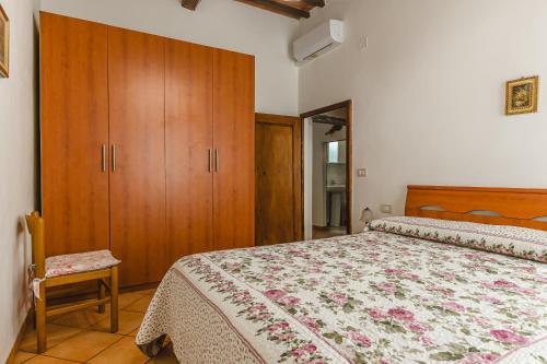 a bedroom with a bed and a wooden cabinet at Casa Luana in Lucignano