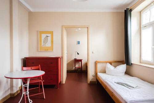a bedroom with a bed and a table and a table at Fabrik Gästehaus in Neustrelitz
