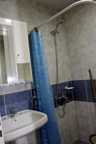 a bathroom with a blue shower curtain and a sink at Departamento Monte Hermoso in Monte Hermoso