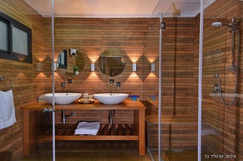 a bathroom with two sinks and a shower at מקום טוב באמצע במושבת כנרת in Kinneret
