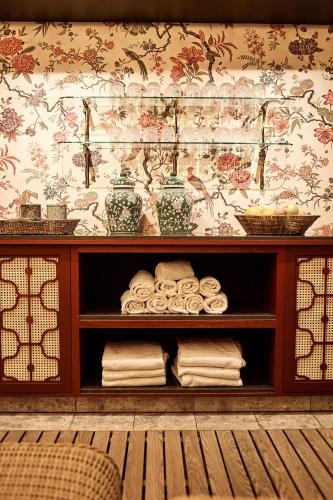 a shelf with towels and vases on a wall at Savoy 1918, a member of Small Luxury Hotels of The World in Oslo