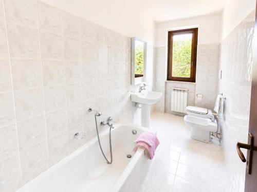 a bathroom with a tub and a sink and a toilet at Dolce Vita LakeView - By Turidea in Sale Marasino
