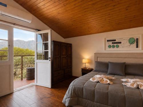 a bedroom with a bed with a wooden ceiling at Cabañas Caranday in Capilla del Monte