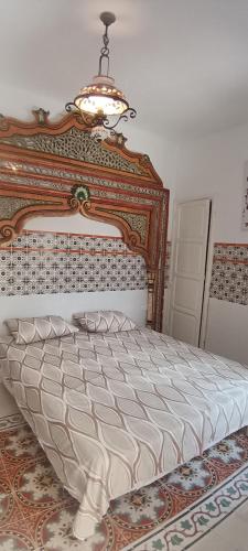 a bedroom with a large bed with a wooden headboard at Dar HJAIJA in Hammamet