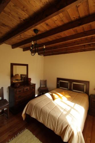a bedroom with a bed with a dresser and a mirror at Quinta Moinho Meirinho in Crato
