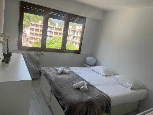 a bedroom with a bed with two towels on it at Appartement la Liberté in Albertville