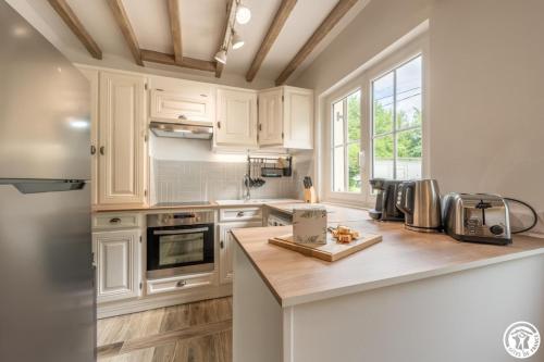 a kitchen with white cabinets and a counter top at Le beloiseau in Breteuil