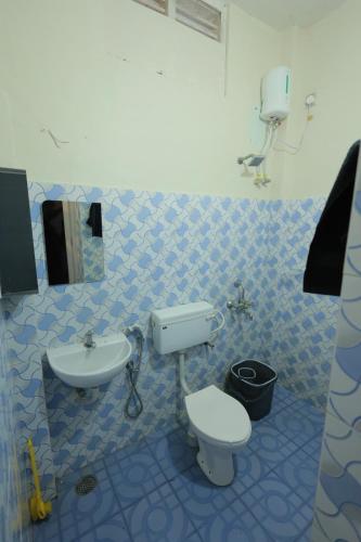 a blue and white bathroom with a toilet and a sink at SITER Holidays Villa in Kovalam