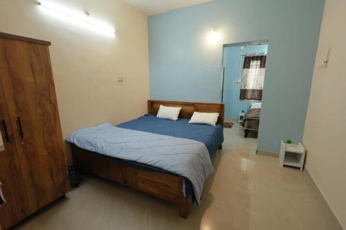 a bedroom with a bed with blue sheets and a mirror at SITER Holidays Villa in Kovalam