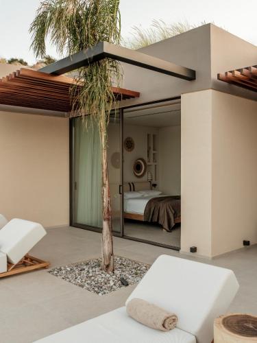 a house with a palm tree in front of a bedroom at Gaia Place in Agios Nikolaos