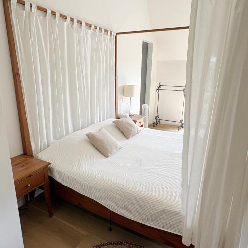 a bedroom with a large bed with white curtains at De Watermolen in Ninove