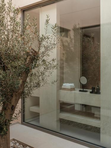 a room with a glass wall with a mirror at Gaia Place in Agios Nikolaos