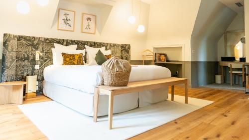 a bedroom with a white bed and a table at Briqueterie Champagne, A Beauvallon Hotel & Spa in Vinay