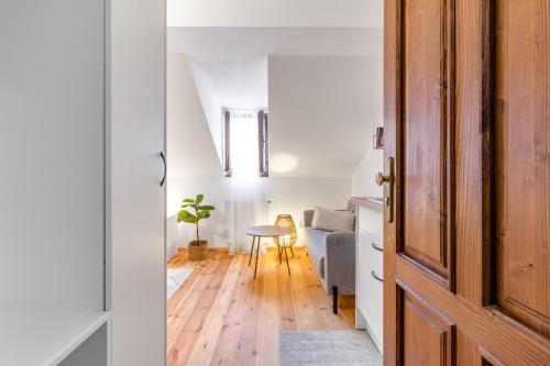 a living room with a wooden door and a table at Apartmán TICHO - Ostrůvek in Lesná