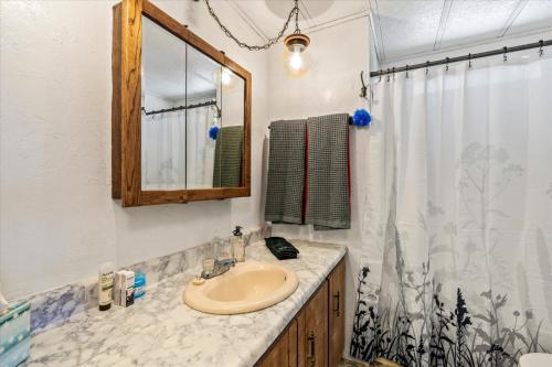 a bathroom with a sink and a mirror at Cozy Desert Hideaway in Tucson