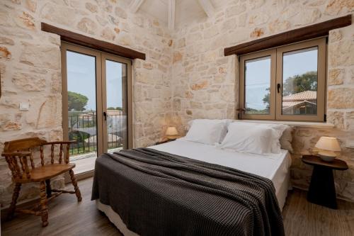 a bedroom with a bed and two windows at Casa Falco in Vasilikos