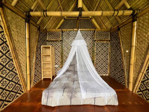 a bed in a room with a netting structure at Rafka Bamboo Valley in Seribatu