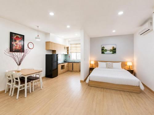 a bedroom with a bed and a table and a kitchen at Maro Hotel & Apartment in Nha Trang