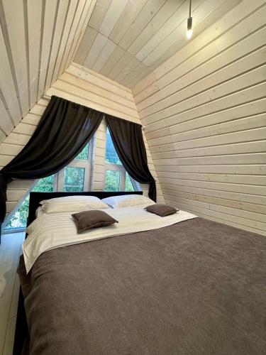 a bedroom with a large bed in front of a window at Шале WeLKoMe in Verkhovyna