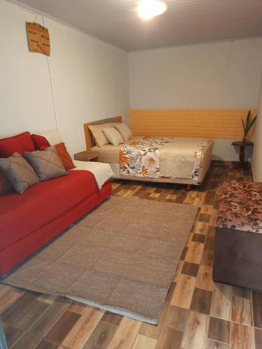 a living room with a couch and a bed at Hospedagem Jabuti no Centro de São Jorge in Sao Jorge