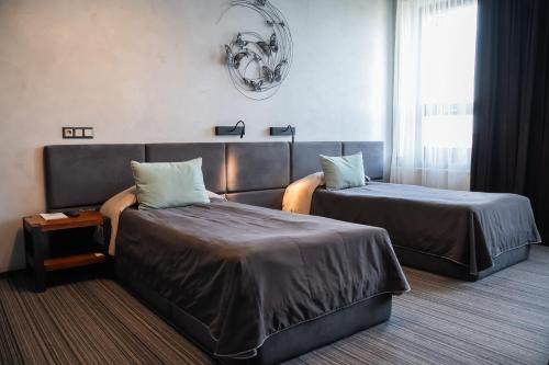 ein Hotelzimmer mit zwei Betten und einem Fenster in der Unterkunft MOJO HALL Hotel in Luzk