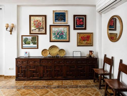 a room with a wooden dresser with paintings on the wall at Aromas del Raposo in Puebla de Sancho Pérez