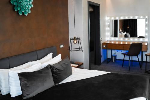 ein Schlafzimmer mit einem Bett und einem Schreibtisch in einem Zimmer in der Unterkunft MOJO HALL Hotel in Luzk
