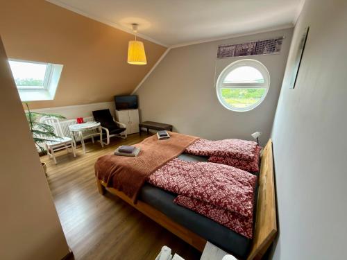a small bedroom with a bed and a window at Ulics vendégház II in Zalacsány