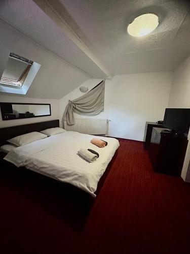 a bedroom with a white bed with a red carpet at Hotel Bran Dracula in Bran