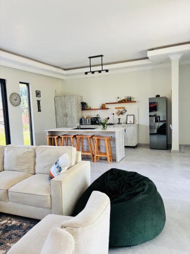 ein Wohnzimmer mit Sofa und eine Küche in der Unterkunft Bougainvillea House in Mwaja