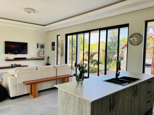 ein Wohnzimmer mit Sofa und Tisch in der Unterkunft Bougainvillea House in Mwaja