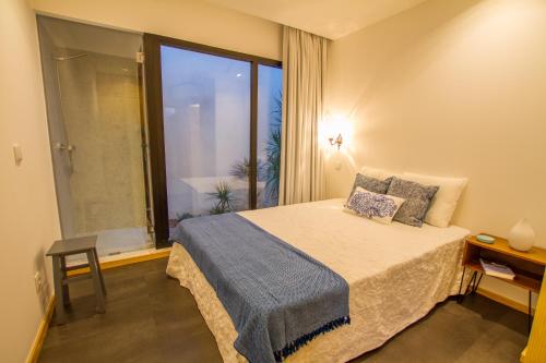アヴェイロにあるCasa dos Mercanteisのベッドルーム1室(ベッド1台、大きな窓付)