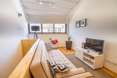 a living room with a couch and a tv at Casa dos Mercanteis in Aveiro
