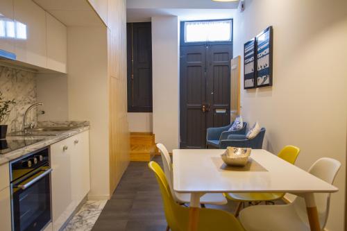 a kitchen and dining room with a table and chairs at Casa dos Mercanteis in Aveiro