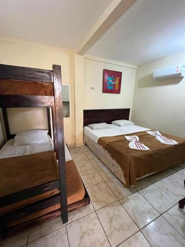 a bedroom with two beds and a bunk bed at Pousada dos Pássaros Pipa in Pipa
