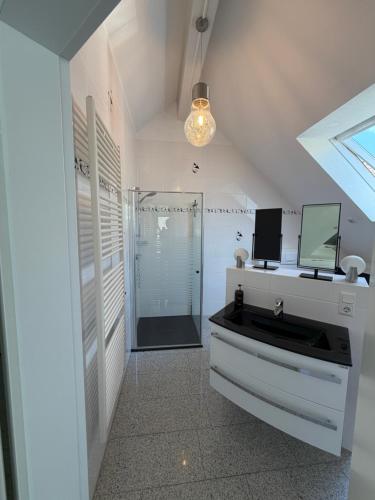 a bathroom with a sink and a shower with a mirror at Burgblick in Bernkastel-Kues