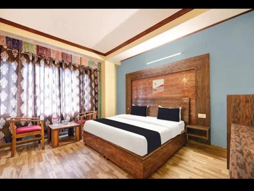 a bedroom with a large bed and a chair at Tara Regency Hotel in Shimla