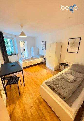 a room with two beds and a desk in it at BEGE APARTMENTS Business Studio in Hagen
