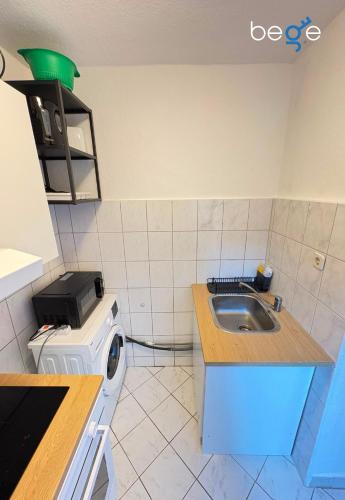 a kitchen with a sink and a washing machine at BEGE APARTMENTS Business Studio in Hagen